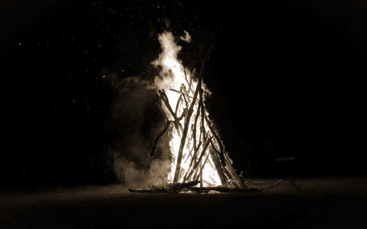 Brennende Holzkonstruktion mit Funkenflug in der Nacht — IltisBurn