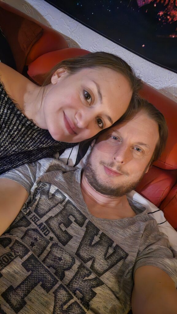Florian und Eliana kuschelnd auf dem Sofa zu Hause